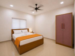 a bedroom with a bed and a ceiling fan at Kannur Easy Nest in Kannur