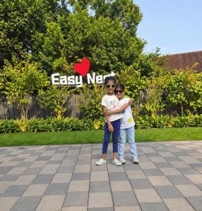 two young children standing in front of a sign at Kannur Easy Nest in Kannur