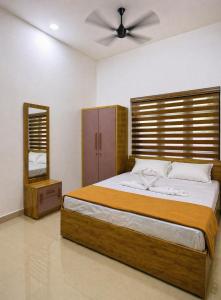 a bedroom with a large bed and a mirror at Kannur Easy Nest in Kannur