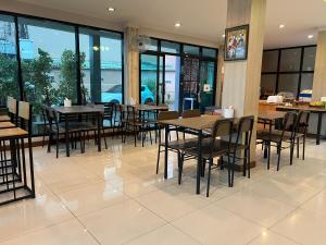 a dining room with tables and chairs and windows at ช้างเผือกเกสต์เฮ้าส์ Changphueak Guesthouse in Nan