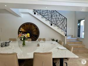 a dining room with a table and a staircase at Gîte Côté Brevon - 12 pers in Échalot