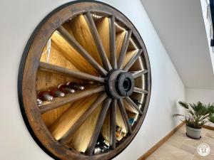 a wooden wagon wheel on a wall with wine bottles at Gîte Côté Brevon - 12 pers in Échalot +36 photos