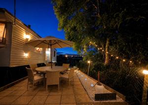 a table with an umbrella on a patio at night at Seaside Escape at St Osyth in Clacton-on-Sea
