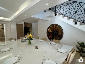 a dining room with a white table and a staircase at Gîte Côté Brevon - 8 pers in Échalot