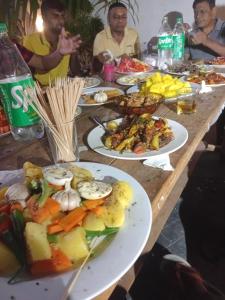 a group of people sitting at a table with plates of food at Seven Crest Hotel Anuradhapura in Anuradhapura +44 photos