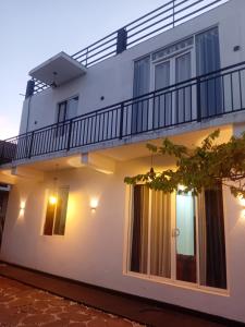 a white house with a balcony at Seven Crest Hotel Anuradhapura in Anuradhapura