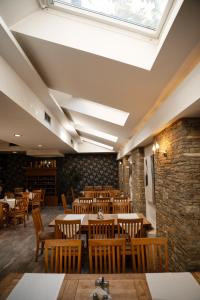a restaurant with wooden tables and chairs and a skylight at Hotel Centrum Prizren in Prizren +54 photos