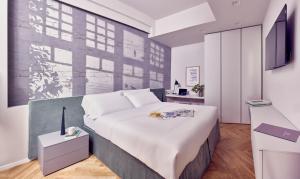 a bedroom with a large white bed and a desk at La Dimora Guest House in Castel di Sangro