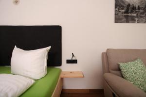 a room with a couch and a pillow and a chair at #demmi´s Zirbenstube in Altstädten +3 photos