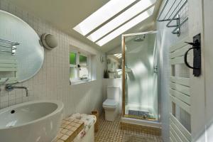 a bathroom with a tub and a toilet and a skylight at Finest Retreats - Lavender Cottage in Methwold +17 photos