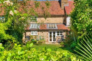 an old stone house with red roof at Finest Retreats - Lavender Cottage in Methwold