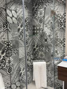 a bathroom with a shower with black and white tiles at CONTINENTAL DARVOZ Hotel in Dashtak +8 photos