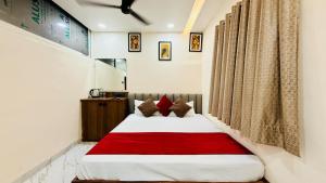 a bedroom with a bed with a red blanket at Hotel Gurukripa Palace in Maheshwar