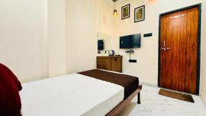 a bedroom with a bed and a wooden door at Hotel Gurukripa Palace in Maheshwar