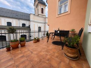 a patio with potted plants and a building with a clock tower at Apartmán siedmy div in Banská Štiavnica