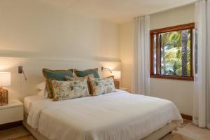 a white bed in a room with a window at Villa Itzaga by muse villas in Post of Flacq
