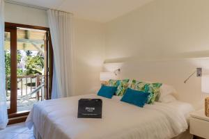 a bedroom with a white bed with blue pillows at Villa Itzaga by muse villas in Post of Flacq