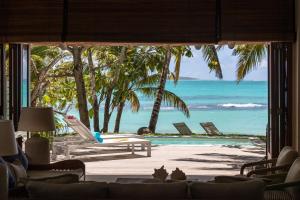 a living room with a view of the beach at Villa Itzaga by muse villas in Post of Flacq