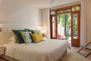 a bedroom with a large white bed with blue and yellow pillows at Villa Itzaga by muse villas in Post of Flacq