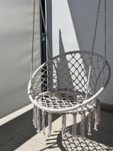 a white rope chair sitting in a window at Apartman Centar - Posušje in Posušje