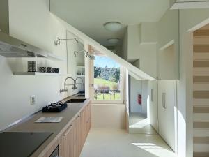 a kitchen with white counters and a large window at franciacorta iseo lake house in Clusane sul Lago