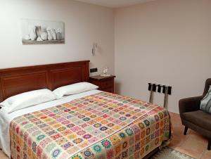 a bedroom with a bed with a colorful quilt at Apartament casa Rural Cal Xico d'Adrall -La Seu d'Urgell-Andorra in Adrall