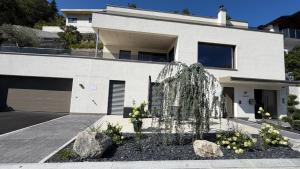 a white house with a fountain in front of it at Nomes Apartment in Axams