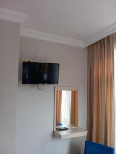 a room with a tv on the wall and a mirror at Sunset Otel in Şile