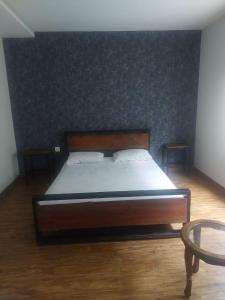 a large bed in a room with a wall at White Ice Cottages in Mānsehra