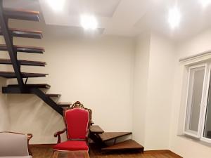 a red chair in a room with a staircase at White Ice Cottages in Mānsehra