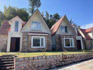 a brick house with a brick wall at White Ice Cottages in Mānsehra