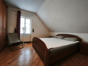 a bedroom with a bed and a window and a chair at Beli oblaki in Gradišče v Slovenskih Goricah