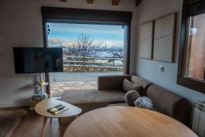 a living room with a couch and a table and a window at Casas del Tremedal in Tremedal