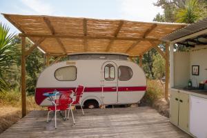 an rv parked under a roof with a table and chairs at Três figos Caravan in São Luis