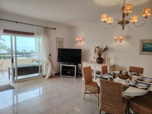 a living room with a dining table and a television at T2 Galé Mar Retreat - Beach in Galé