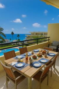 a table with food on a balcony with a view of the ocean at T2 Galé Mar Retreat - Beach in Galé