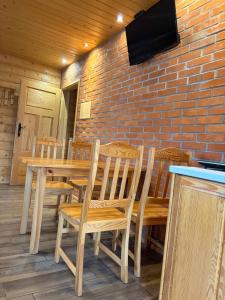 a wooden table with chairs and a television on a brick wall at Agroturystyka Rumcajsówka in Bałtów
