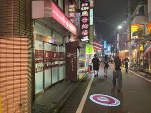 a city street at night with people walking down the street at ホテルグランフォート in Tokyo