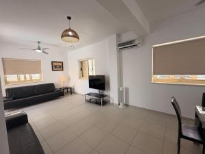 a living room with a couch and a flat screen tv at Pearl House in Paralimni