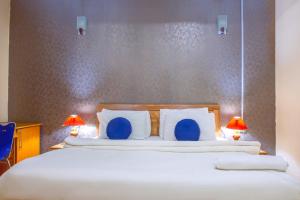 a bedroom with a large bed with blue pillows at Navy Guest House, Kaduna in Kaduna
