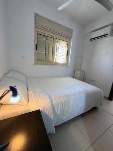 a bedroom with a large white bed with a window at Pearl House in Paralimni +11 photos