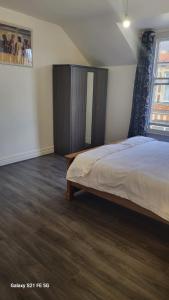 a bedroom with a bed and a cabinet and a window at Montagu Street in Kettering