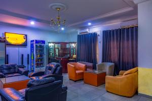 a waiting room with couches and chairs and a television at Navy Guest House, Kaduna in Kaduna