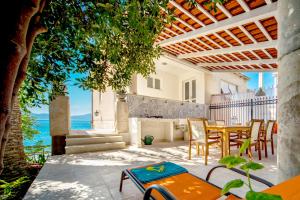a patio with a table and chairs and the ocean at Beach House Labineca in Gradac