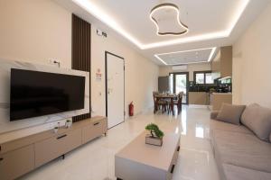 a living room with a large flat screen tv at Glamour Residences 3-4 by CorfuEscapes in Análipsis