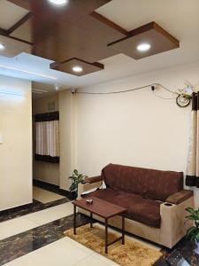 a living room with a couch and a table at Hotel KK Grand in Guntūr