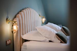 a bedroom with a bed with white pillows at La Villa Ribière in Auxerre
