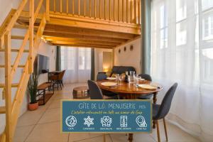 a dining room with a wooden table and a sign at Gîte de La Menuiserie in Gap
