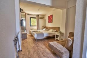 ein Hotelzimmer mit zwei Betten und einer Couch in der Unterkunft Kardes Hotel in Bursa