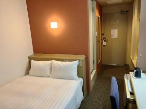 a hotel room with a bed and a hallway at Hotel Premium Green Plus in Sendai